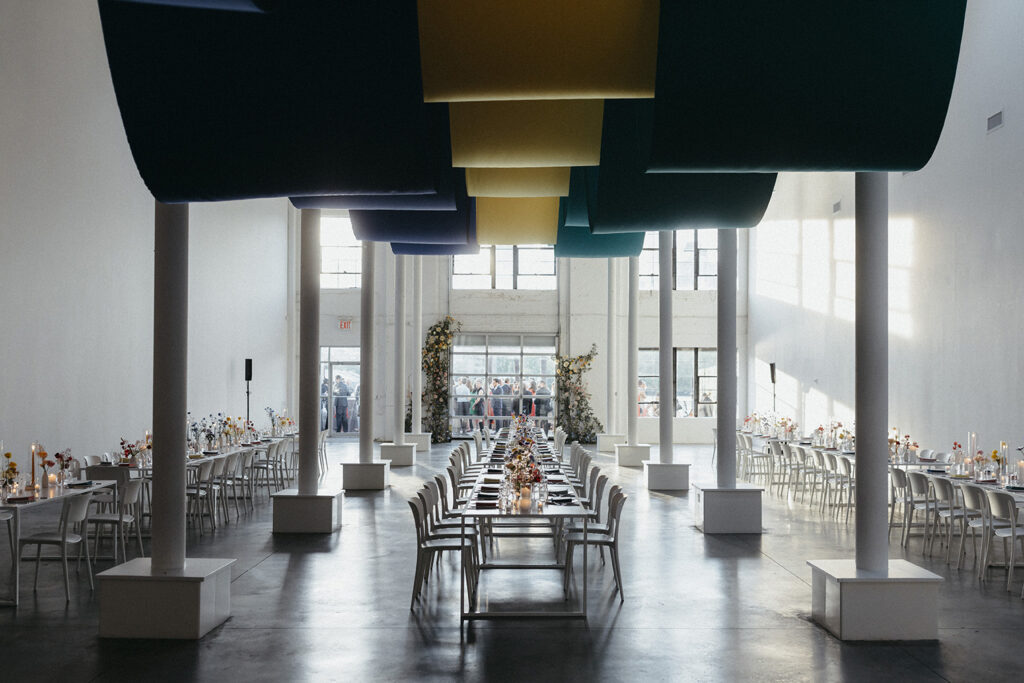 a dinner reception at sound river studios with guests in the background on a dockside terrace