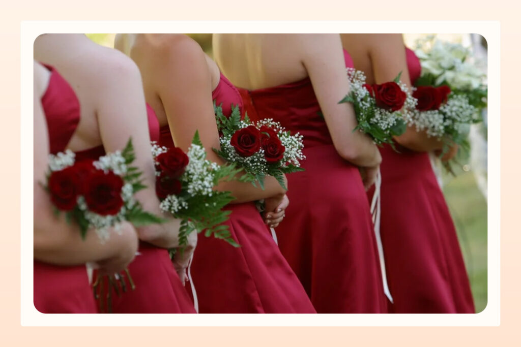 bridal party in red dresses standing in a row
