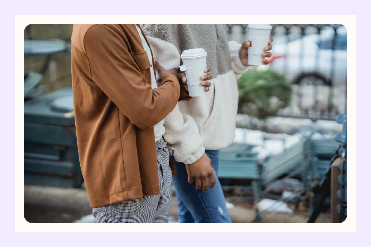 Cropped image of two people walking side by side while both carrying to-go coffee cups