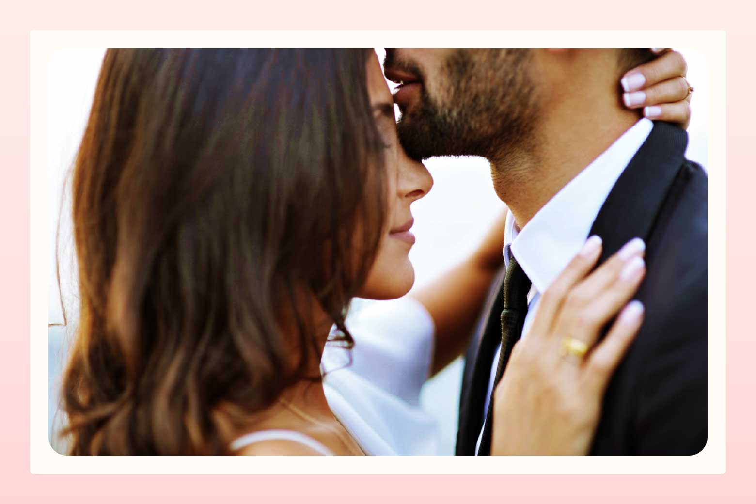 Close up of embracing couple as man kisses woman's forehead