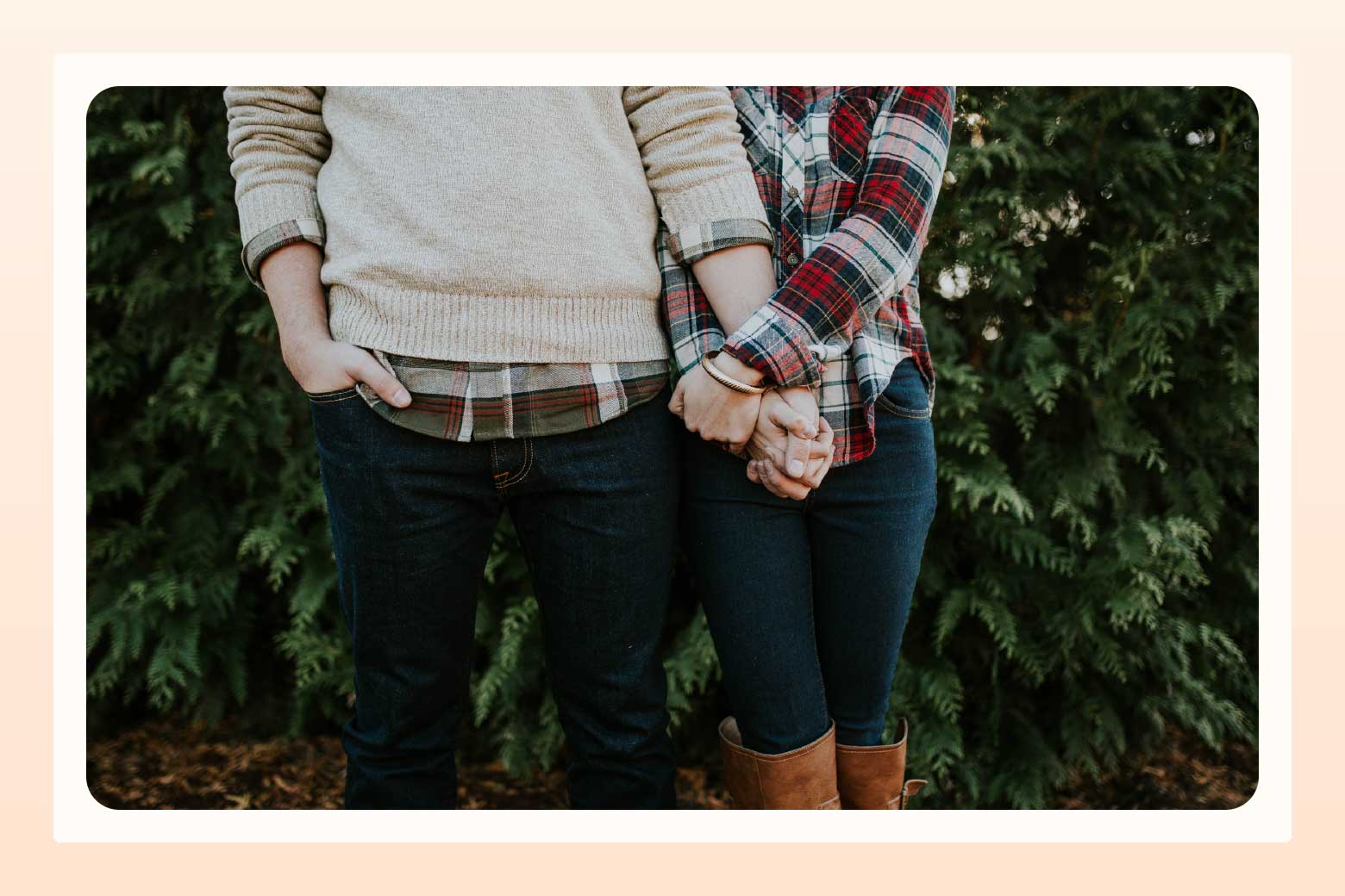 Cropped image of a couple standing closely next to each other while woman holds one of the man's hands in both of hers
