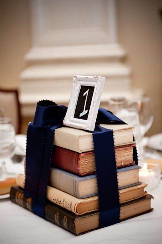 stacks of books wrapped in ribbon as a wedding reception centerpiece