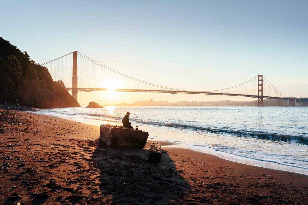 A view of the Golden Gate bridge at sunset from Kirby Cove, a San Francisco engagement photo location