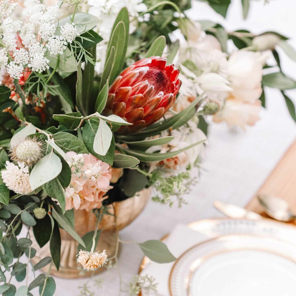 A red flower gives a pop of color to a soft floral arrangement