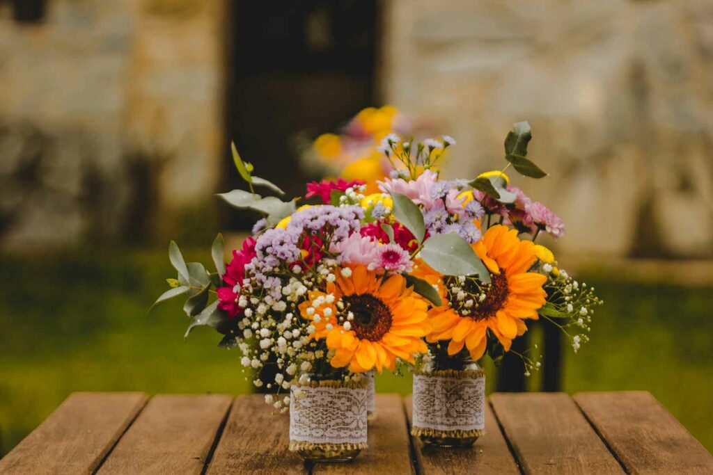 Burlap and lace are wrapped around mason jars to make an adorable rustic centerpiece