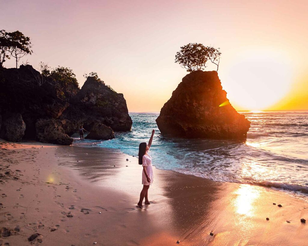 woman in white dress walking on beach during sunset in Bali, Indonesia
