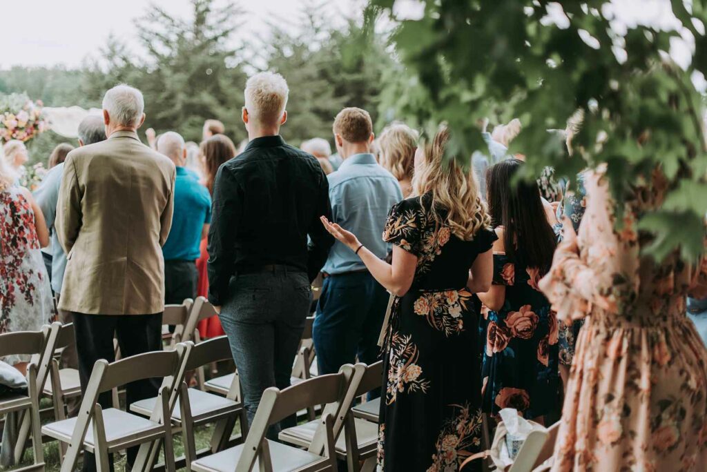 A semi-formal wedding dress code with guests standing in front of chairs