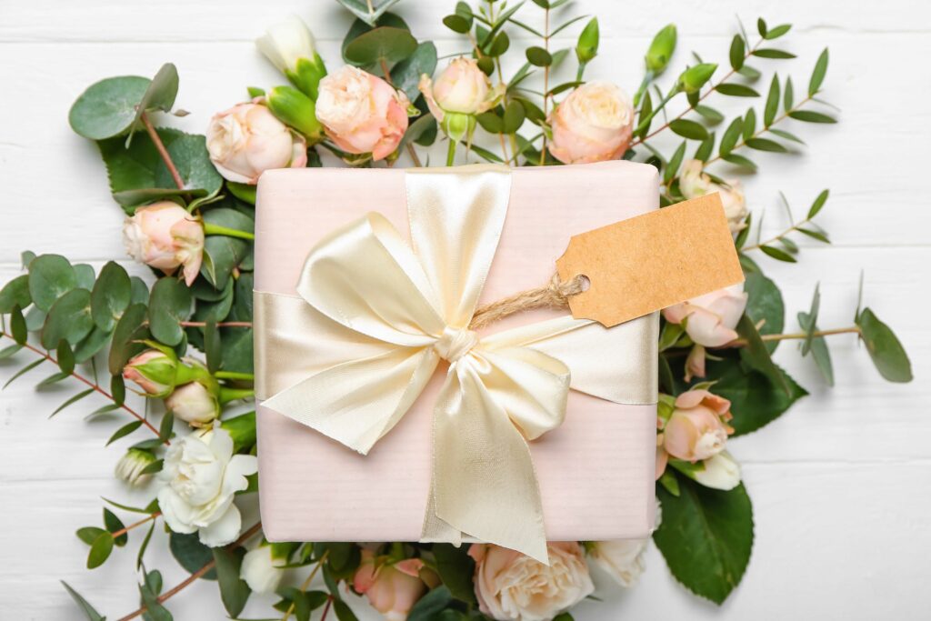 A wedding gift set on top of a wreath of roses and greenery