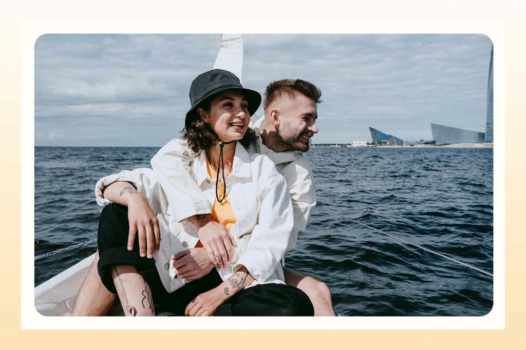 A couple on a boat trip before a beach proposal
