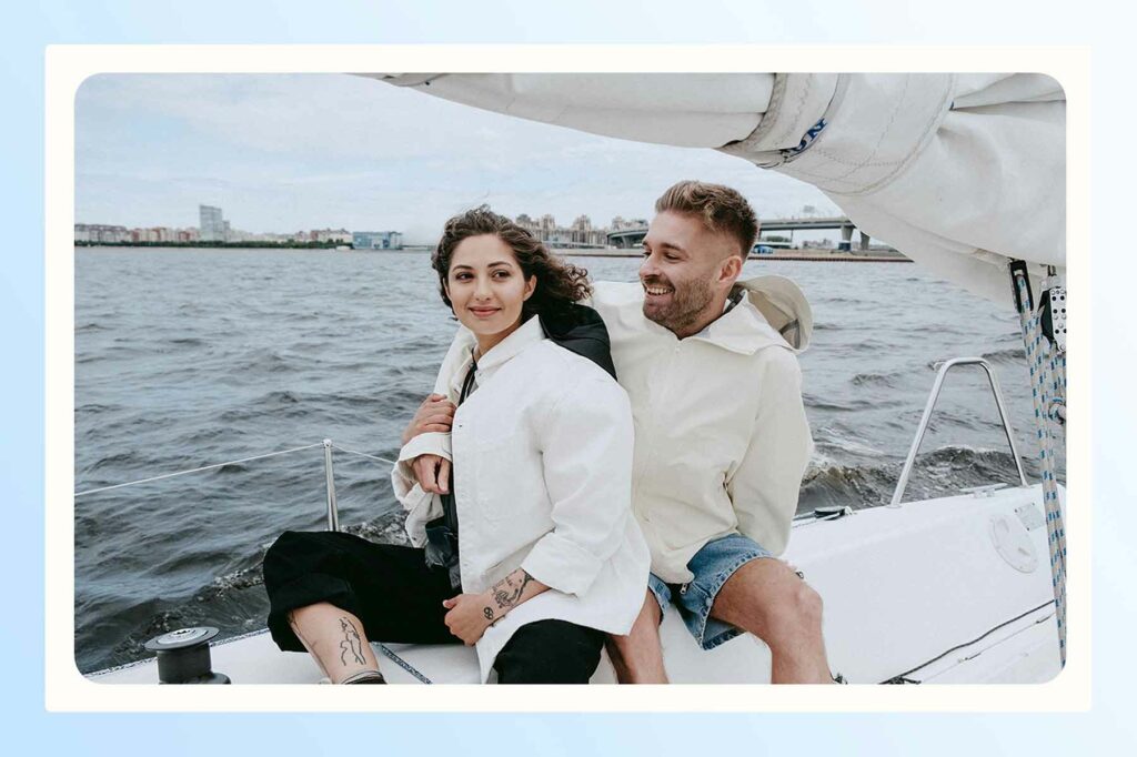 A couple sailing with a cityscape in the background