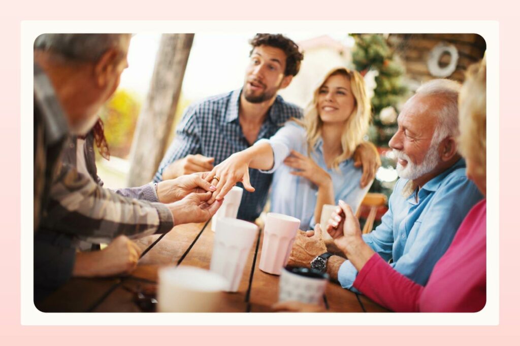 Woman showing her engagement ring to family with her fiancee next to her