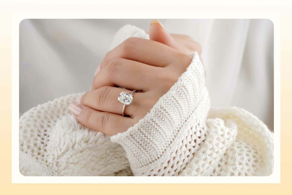 A woman clasping hands with a large engagement ring featured
