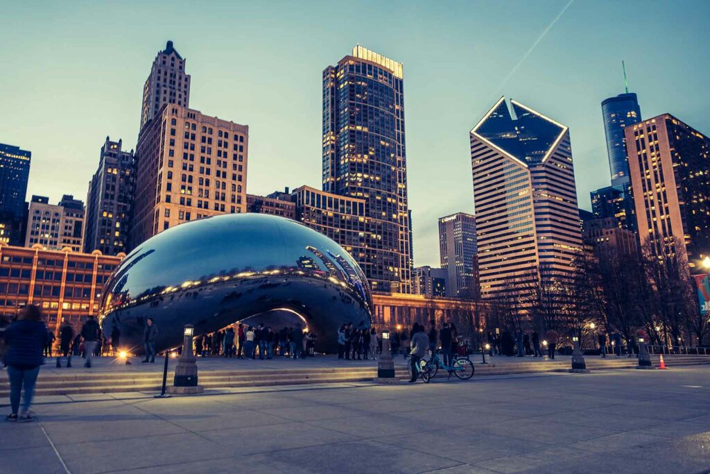 Millennium Park at night with the Bean sculpture and Chicago skyline in the background