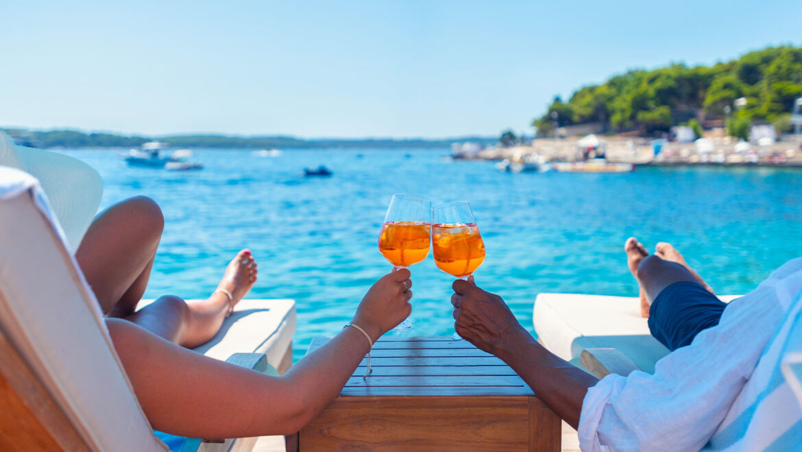newlywed couple relaxing in front of ocean during their honeymoon