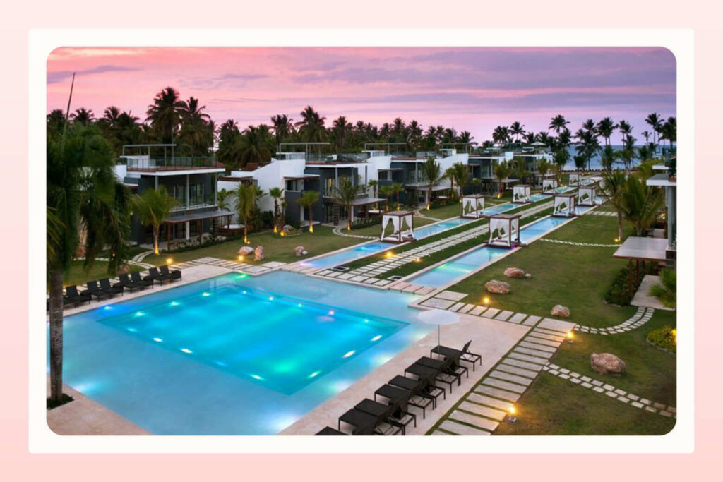 view of beachside resort with pool and cabanas as a honeymoon destination